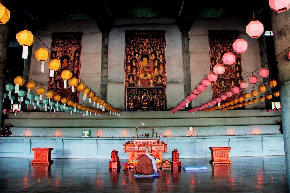 A lone monk praying in the Korean Temple in Lumbini, the two upper floors are a monastery, much like the other international temples in the area.