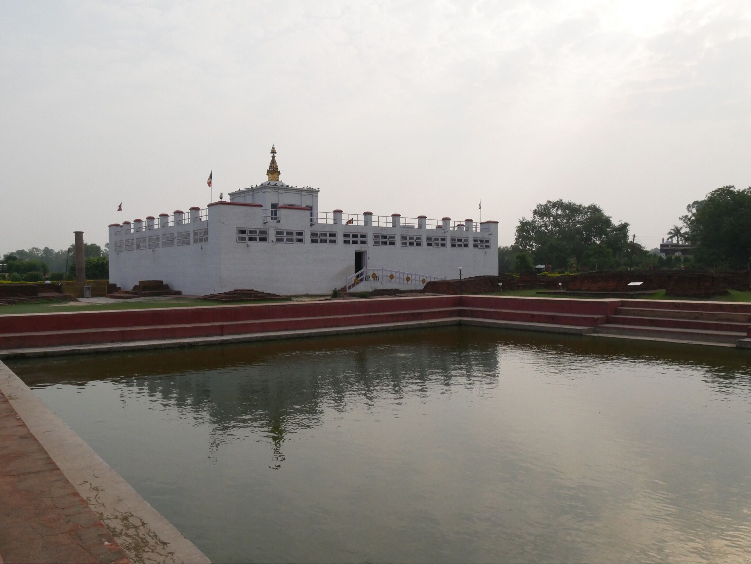 The Maya Devi  temple sits over the spot where the Buddha (Prince Siddhartha) was born. Inside you can see the marker stone that pinpoints the spot where the Buddha was born as well as a sandstone carving of the birth of the Buddha from the 14th century. (No photos inside) The sacred pond in front is where Queen Maya Devi was said to have bathed before giving birth to the Buddha. Lumbini, Nepal.