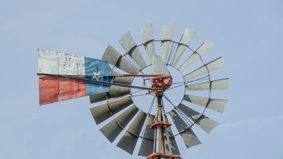 A windmill with a flag featuring blue, white, and red colors.
