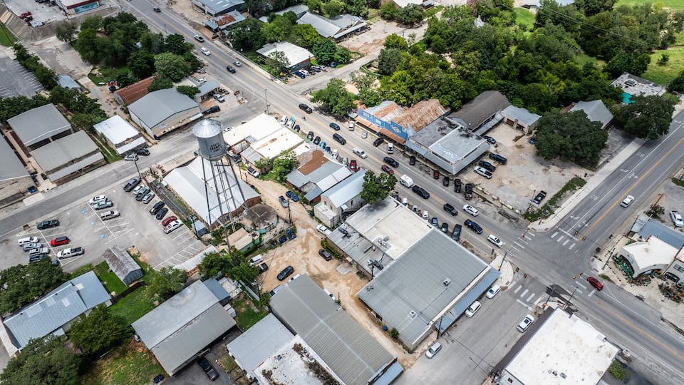 An aerial view of a small town with a main street, several buildings, and a water tower.