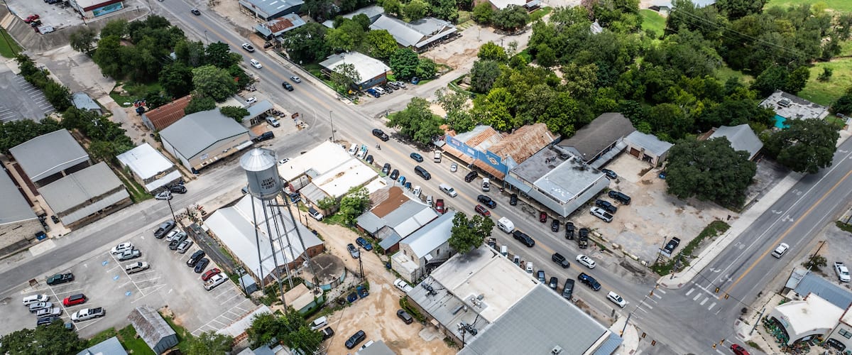 An aerial view of a small town with a main street, several buildings, and a water tower.