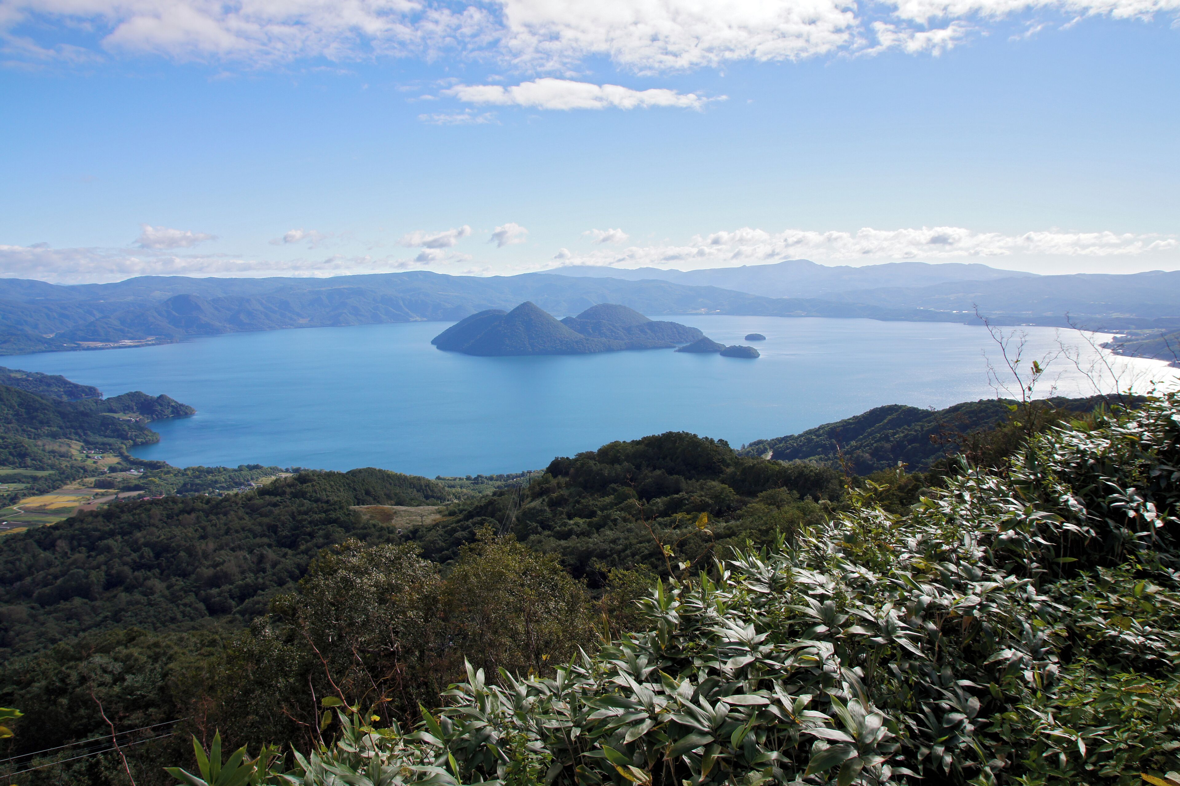 A lake surrounded by mountains and lush greenery.