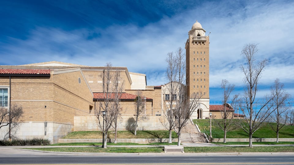 A large brick building with a prominent tower and a dome on top.