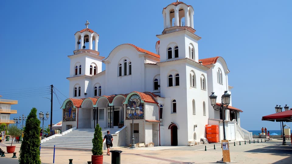 A white church with red-tiled roofs and two bell towers.