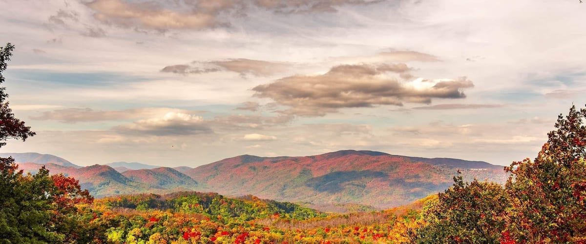 A forested mountain range with autumn foliage.