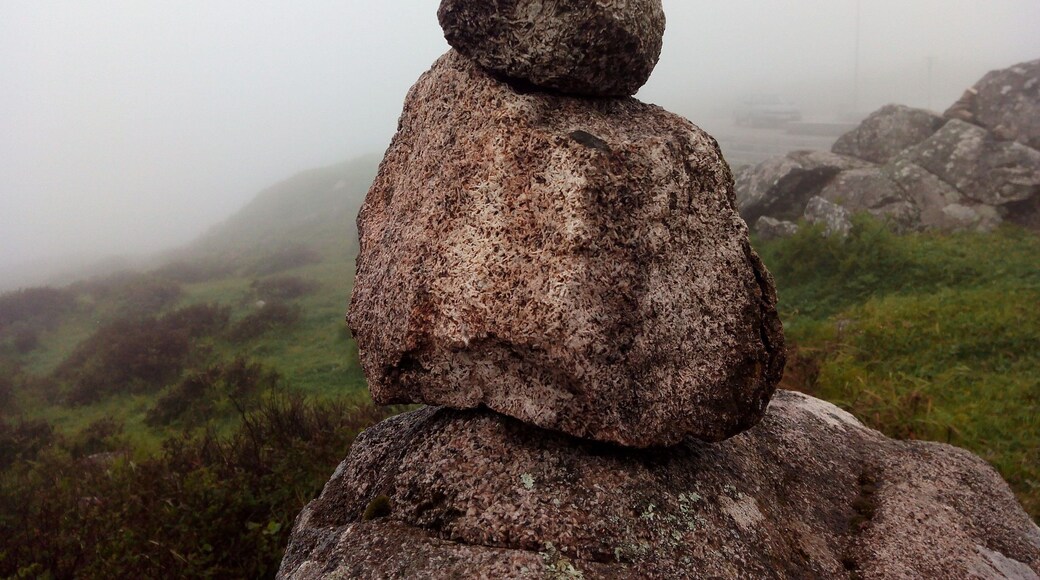 Rocks & sightseeing at the top of a mountain in a foggy day