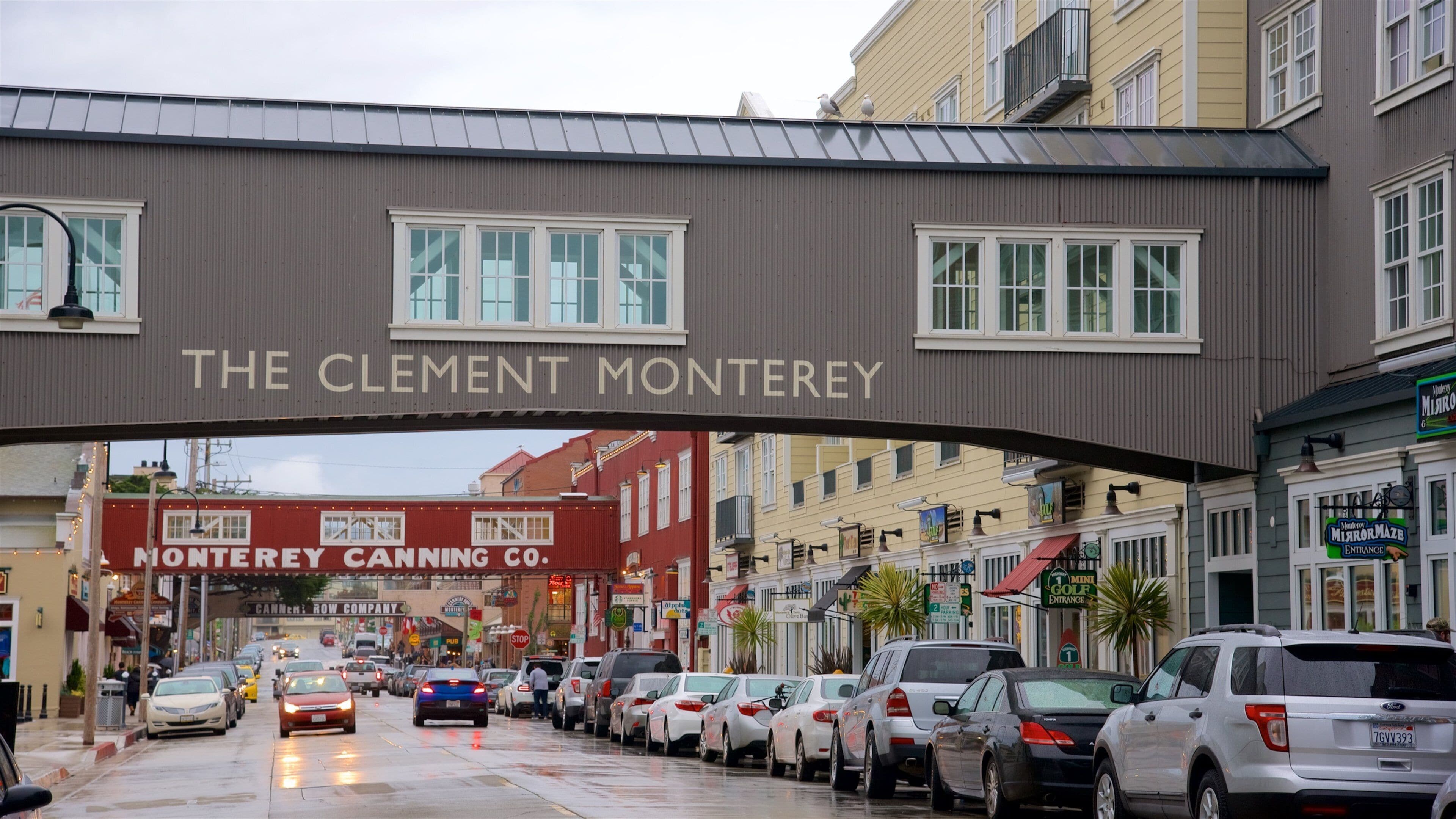 A street with parked cars and a sign reading "The Clement Monterey".
