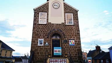 A church with a clock tower, a sign for Gallery Gifts, and a small bell.