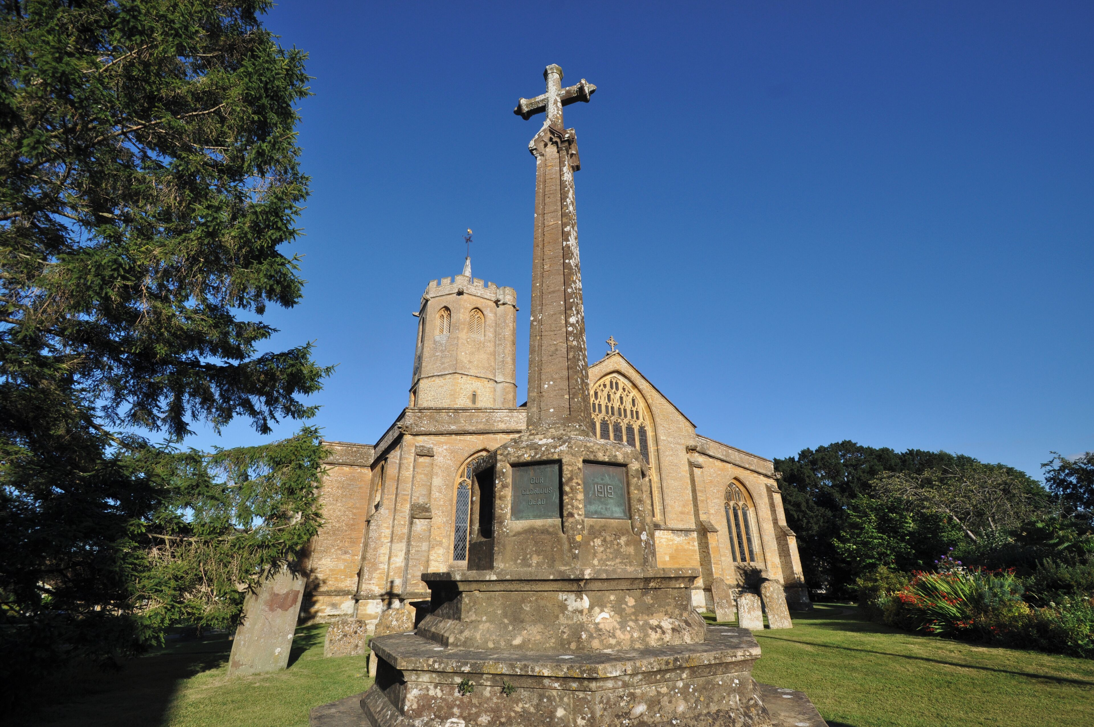 A church with a tall cross, a tower, and a plaque commemorating a 1919 event.