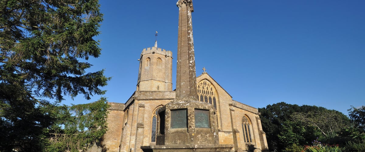 A church with a tall cross, a tower, and a plaque commemorating a 1919 event.