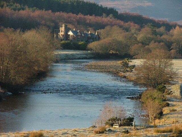 A river flowing through a landscape with a castle-like building in the distance.