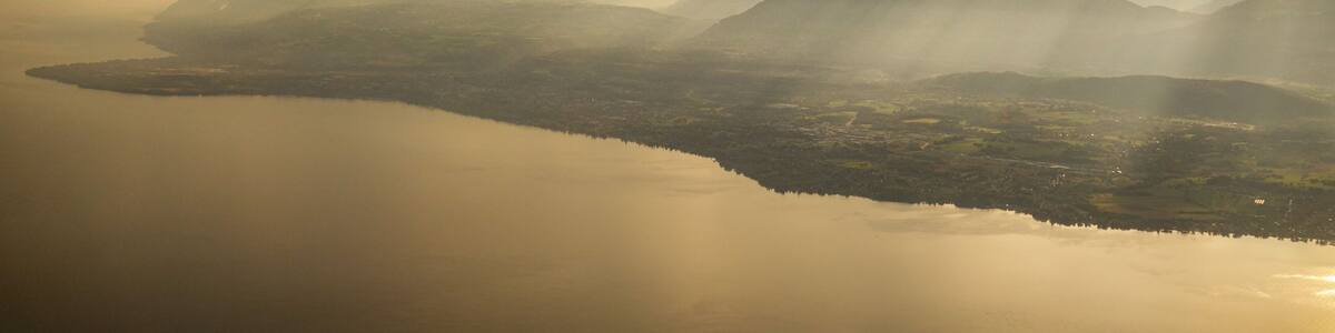 A mountainous landscape with a calm lake reflecting the sky.