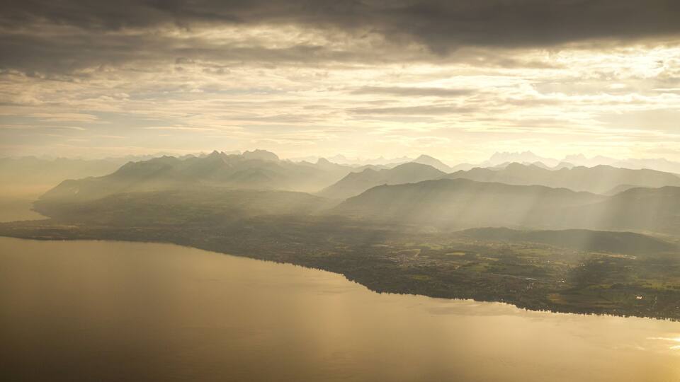 A mountainous landscape with a calm lake reflecting the sky.