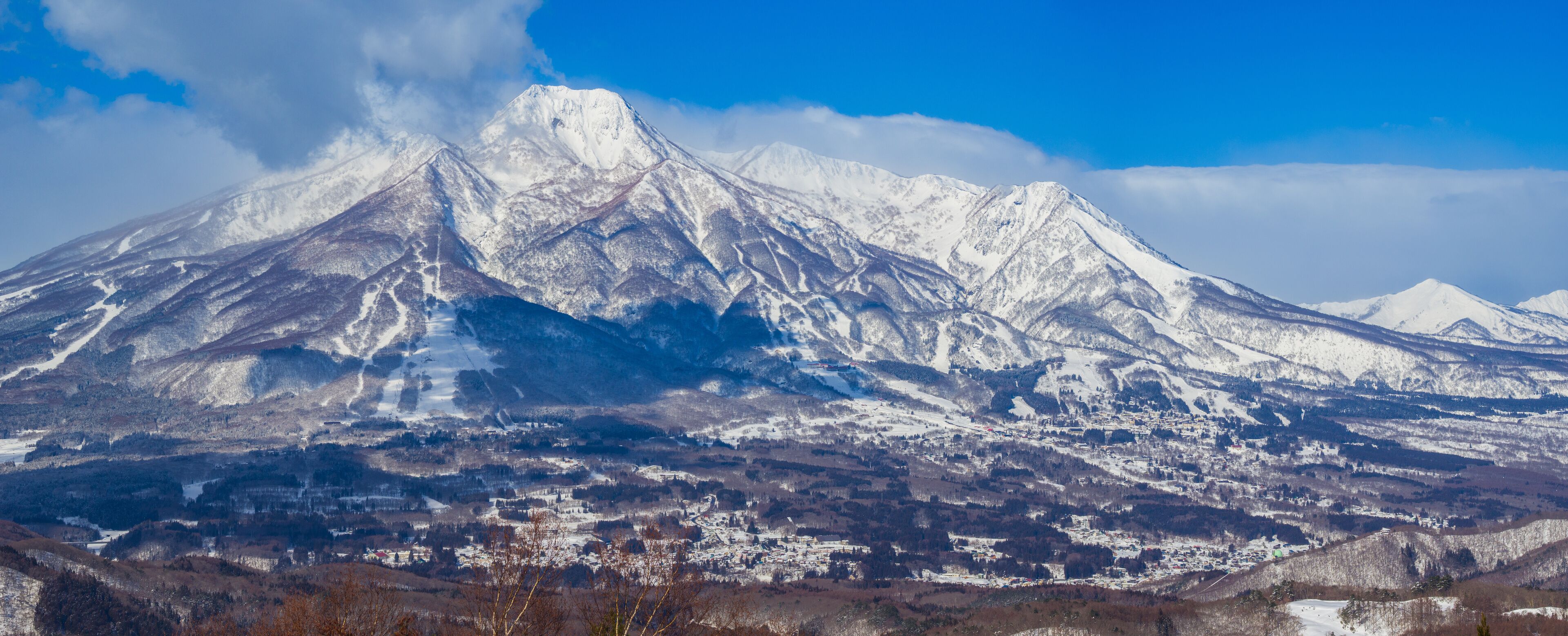 Ski runs and towns visible on the slopes of Mount Myoko on a clear sunny day (viewed from Madarao, Nagano, Japan)