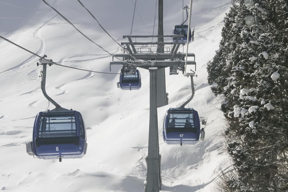 Teleàsics amb tres seients que pugen una pendent nevada.