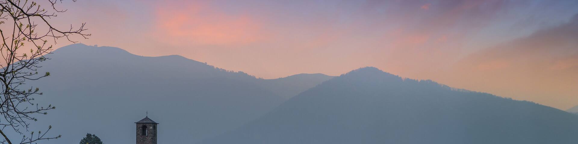 Landscape with a field of flowers in a foreground and a old church in the background. Garbagnate Monastero, Lecco, Italy.