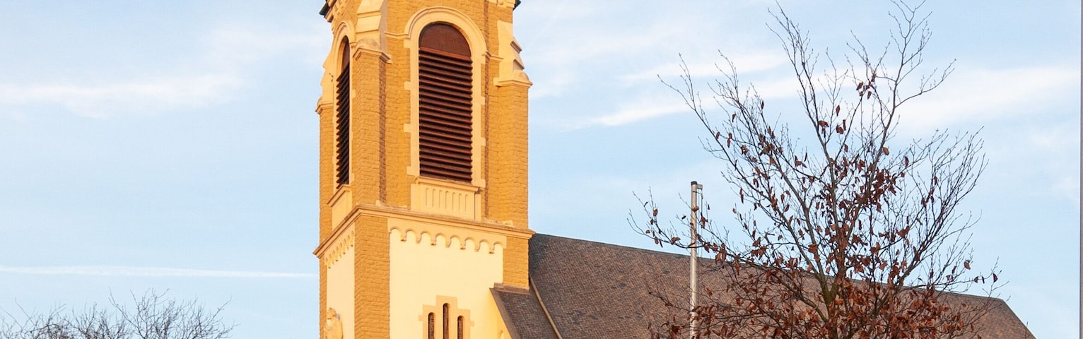 Una iglesia con un campanario alto y una torre del reloj.