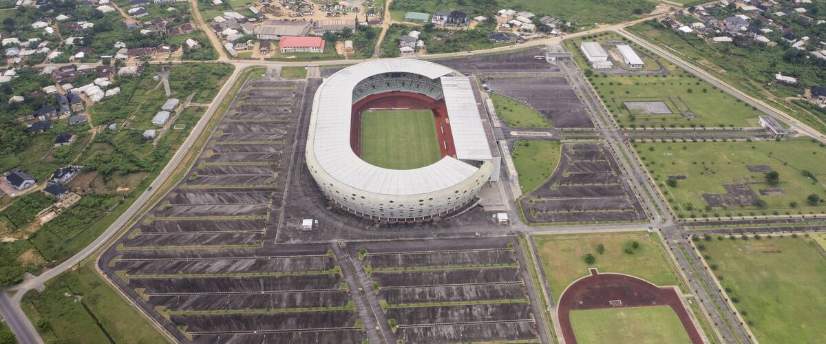 An aerial view of a stadium surrounded by residential areas and green fields.