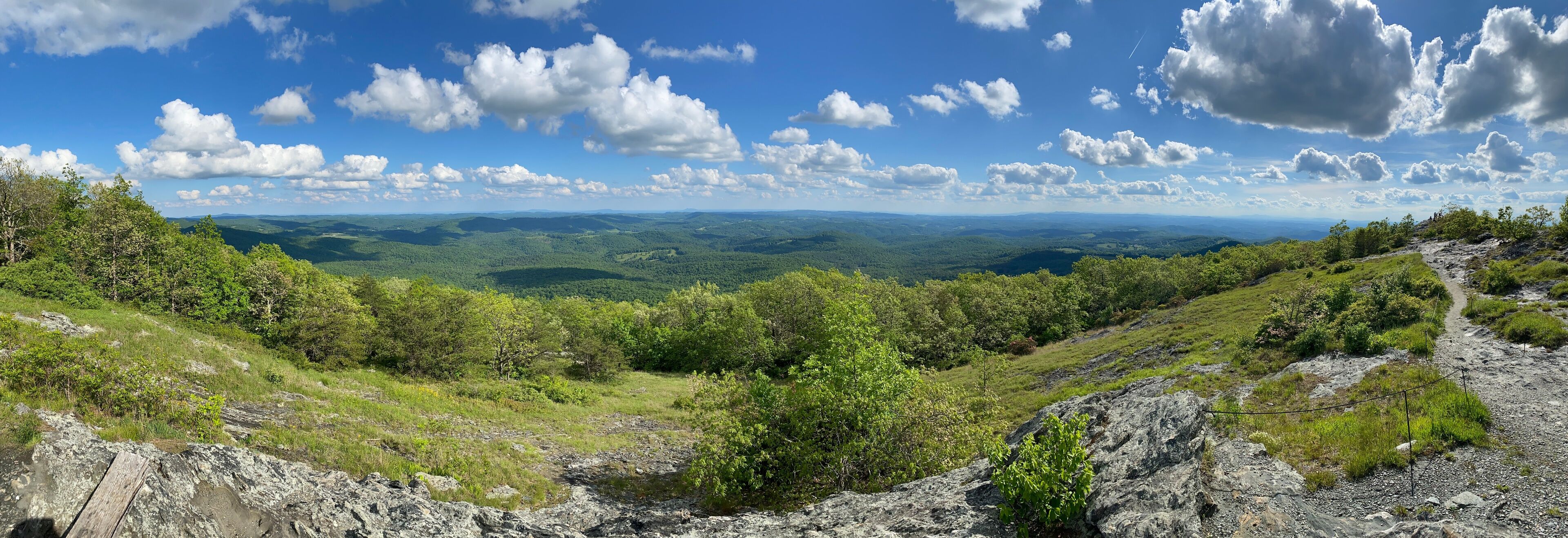 A mountainous landscape with a clear sky and scattered clouds.