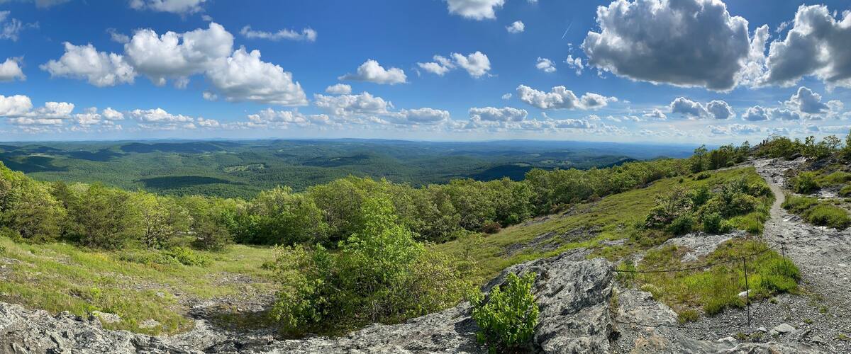 A mountainous landscape with a clear sky and scattered clouds.