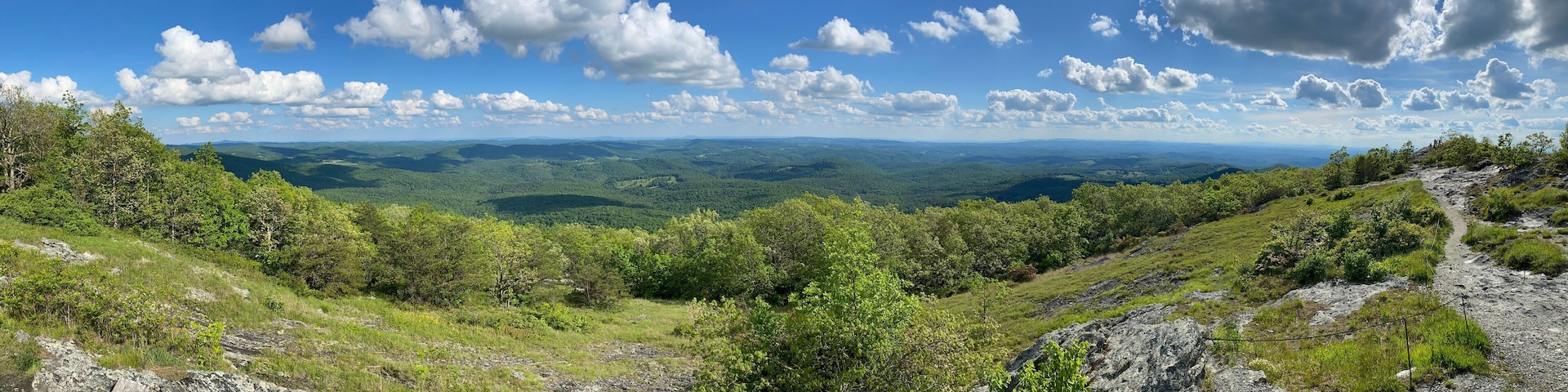 A mountainous landscape with a clear sky and scattered clouds.