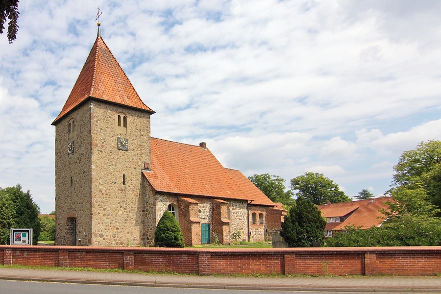 A historic church with a tall tower and a red-tiled roof.