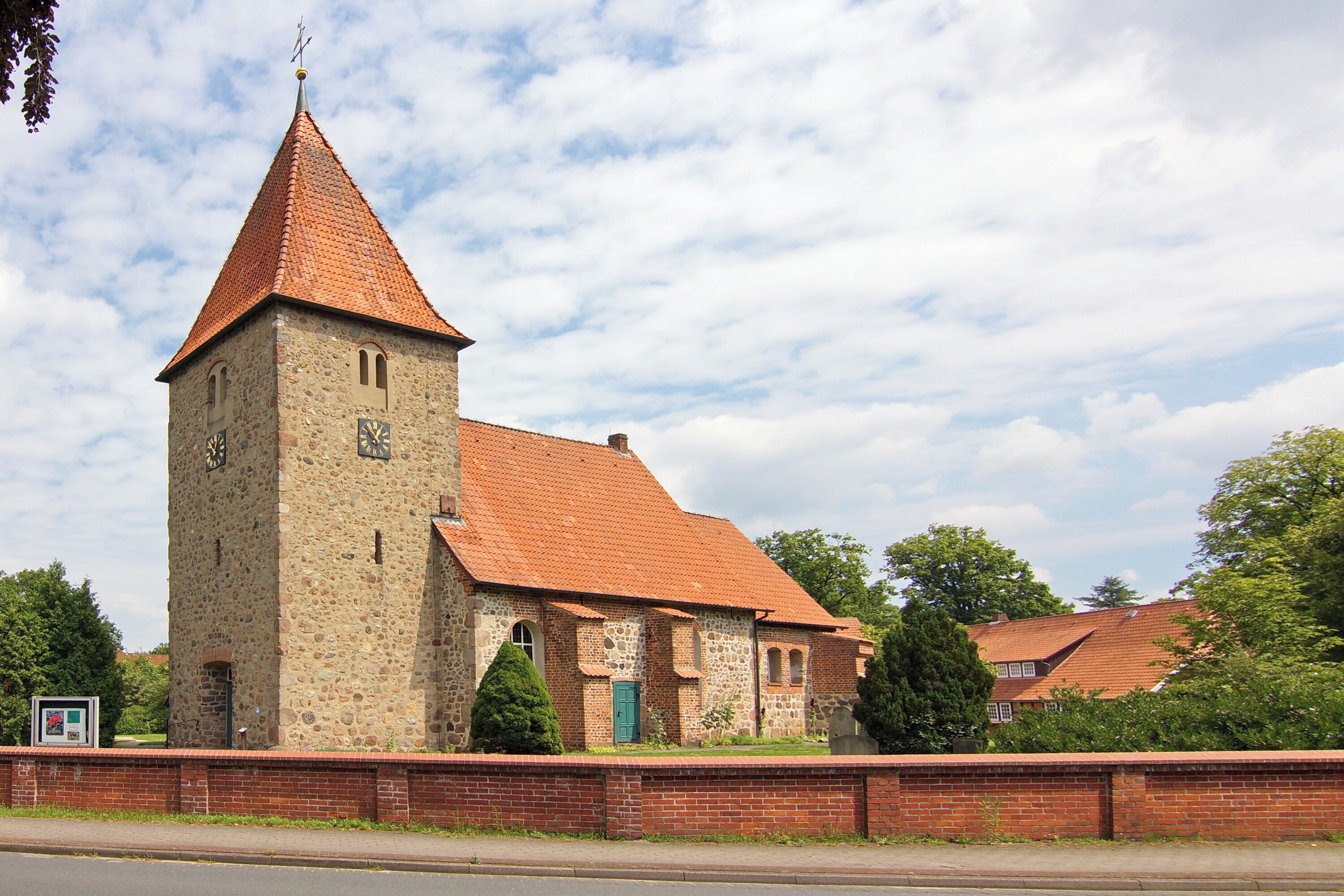 A historic church with a tall tower and a red-tiled roof.