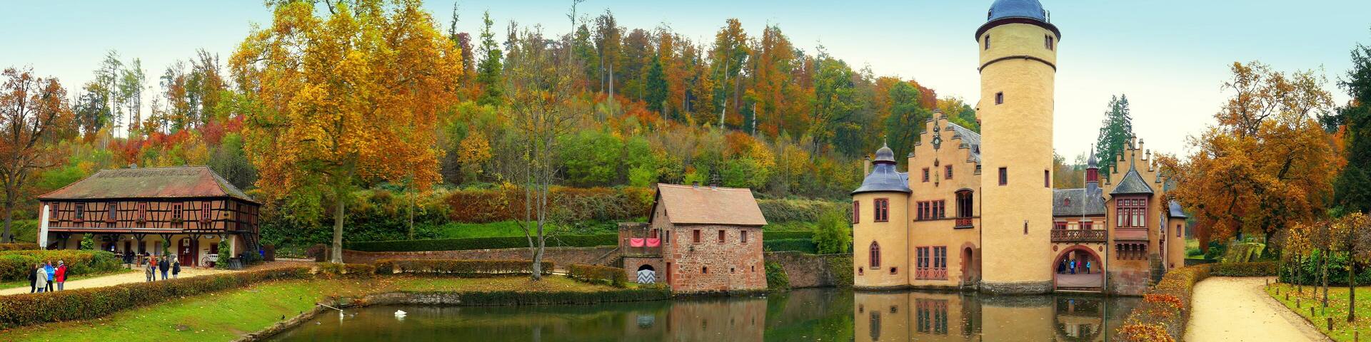 weites Panorama vom Wasserschloss Mespelbrunn im Spessart vor malerischem Wald mit schönem See