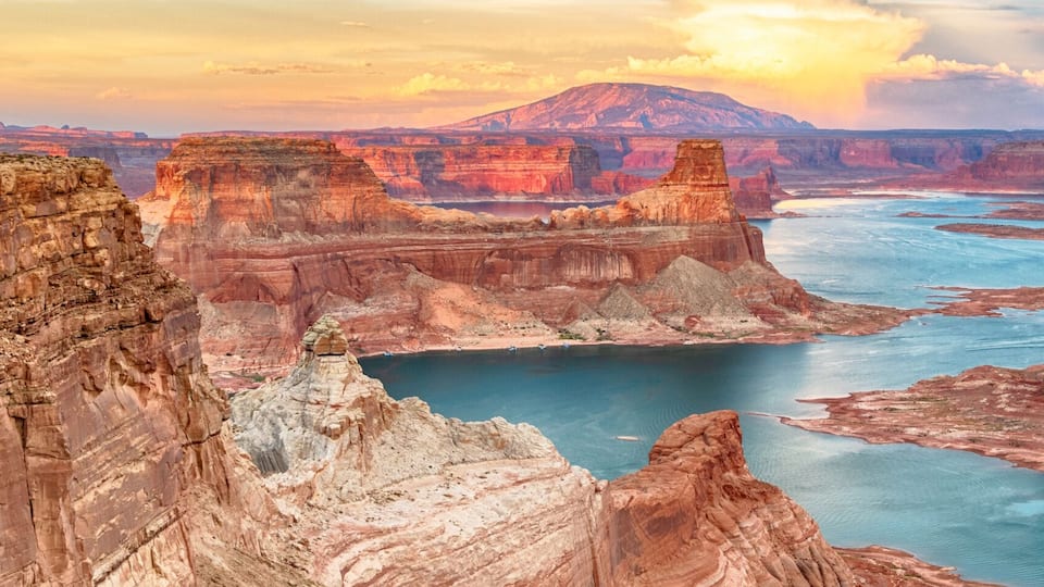 A canyon with a river, cliffs, and a mountain in the background.