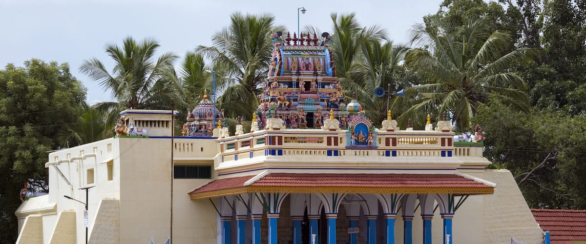 A temple with a multi-tiered roof, blue and white pillars, and a staircase leading to the entrance.