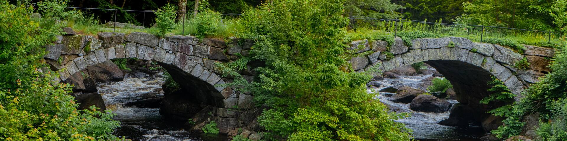 Contoocook River in New Hampshire blue skies and green foliage surrounding the water