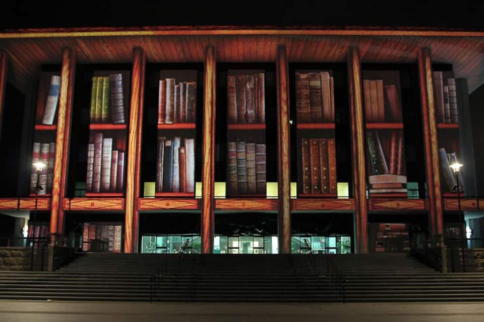 A building with large bookshelves and a staircase leading up to the entrance.