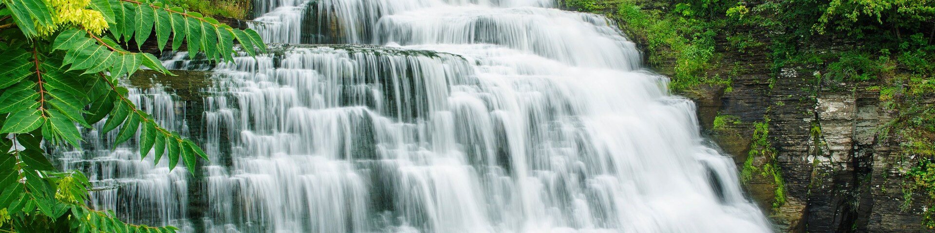 Una cascada en varios niveles rodeada de exuberante vegetación.