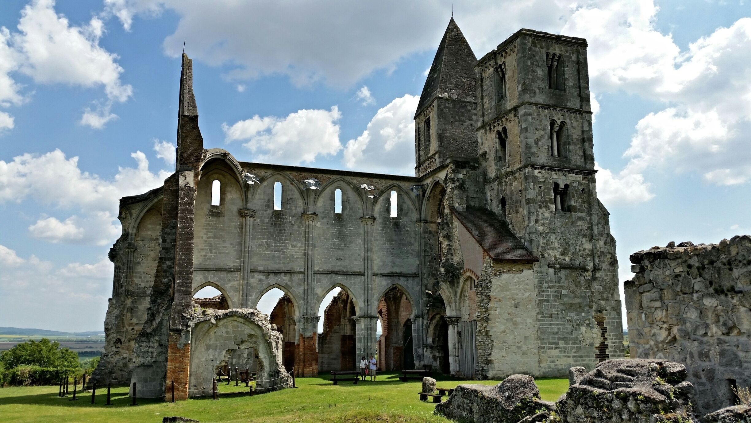 An ancient stone church with arched windows and a tall bell tower.