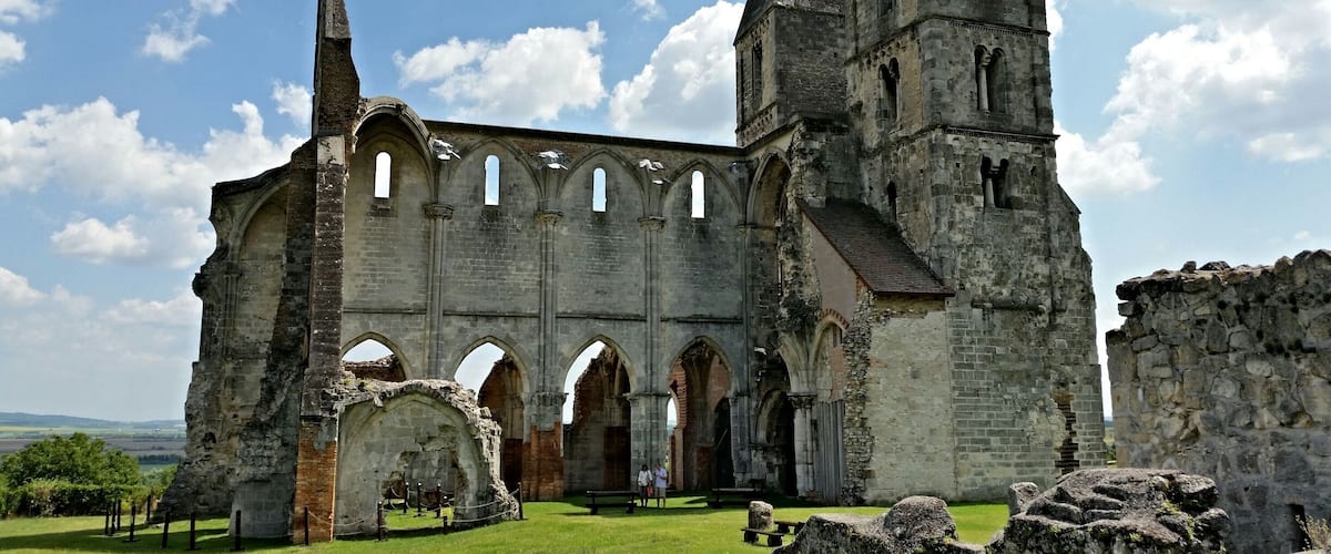 An ancient stone church with arched windows and a tall bell tower.