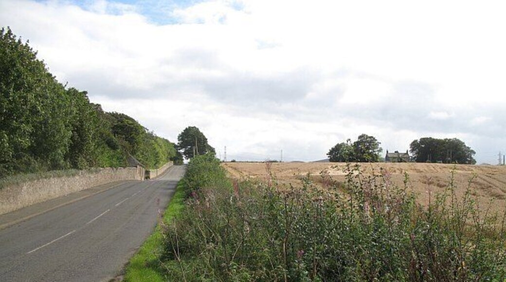 Road beside Riccarton Campus Heriot Watt University lurks behind the policy wall of Riccarton House. Arable land to the right.
