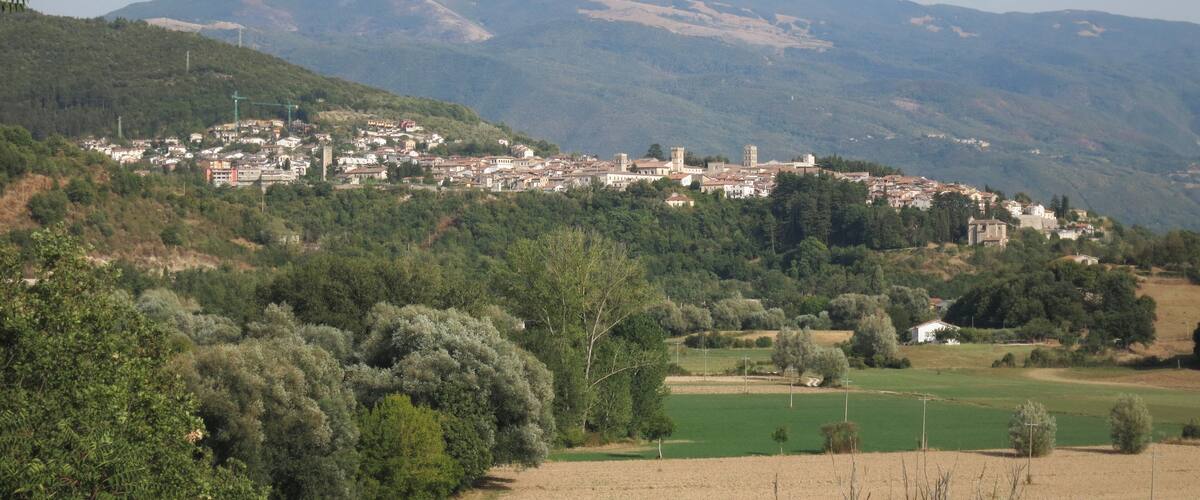A town nestled in a valley with mountains in the background.