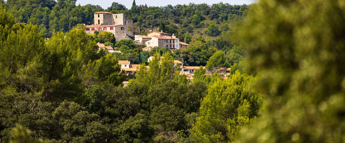 A hillside village with traditional buildings and a prominent tower.