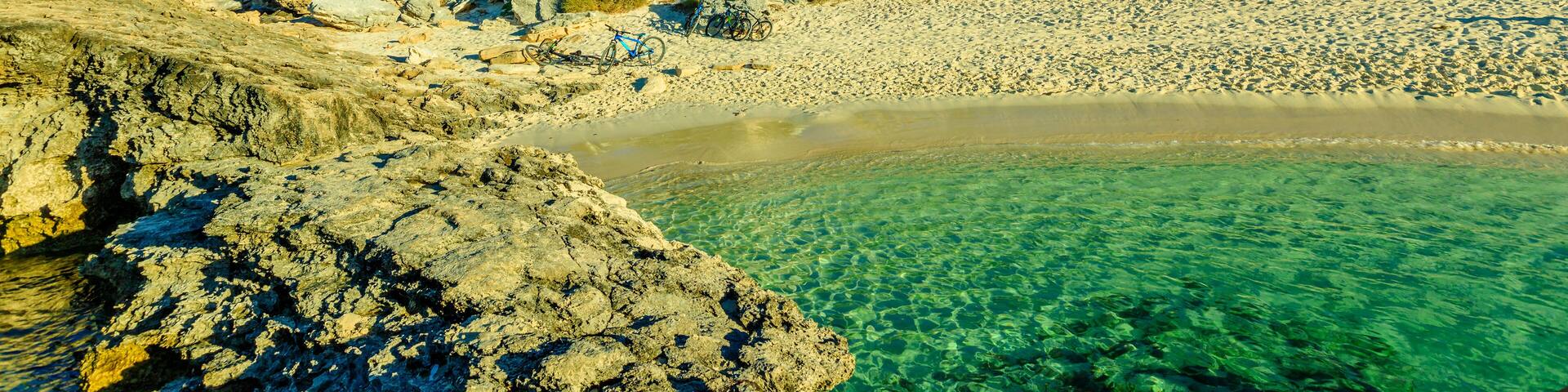 Pinky Beach and Bathurst Lighthouse on background. Turquoise sea and white pristine beach in north coast of Rottnest Island, near Perth, Western Australia.