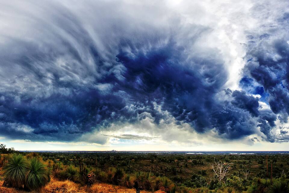 A landscape with a dramatic sky filled with dark clouds.