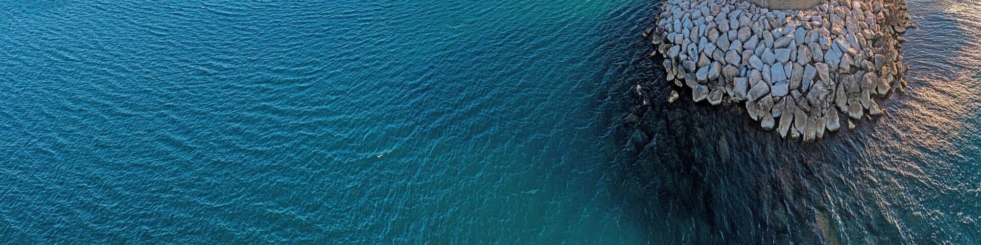 Drone panorama of the Spanish town of Vinaros with the large breakwater at the entrance to the port during sunrise