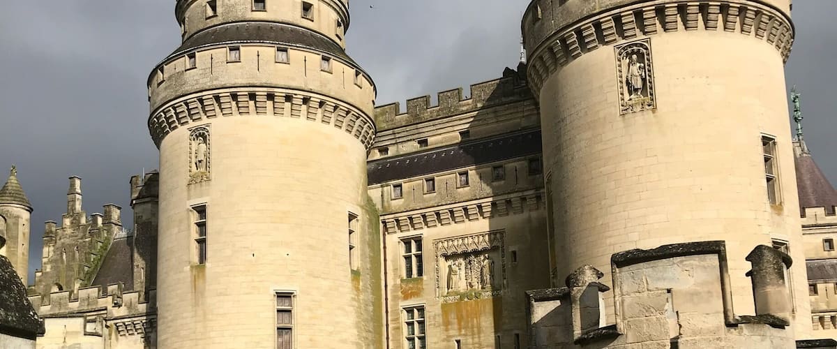 A historic castle with two prominent towers and a fortified wall.
