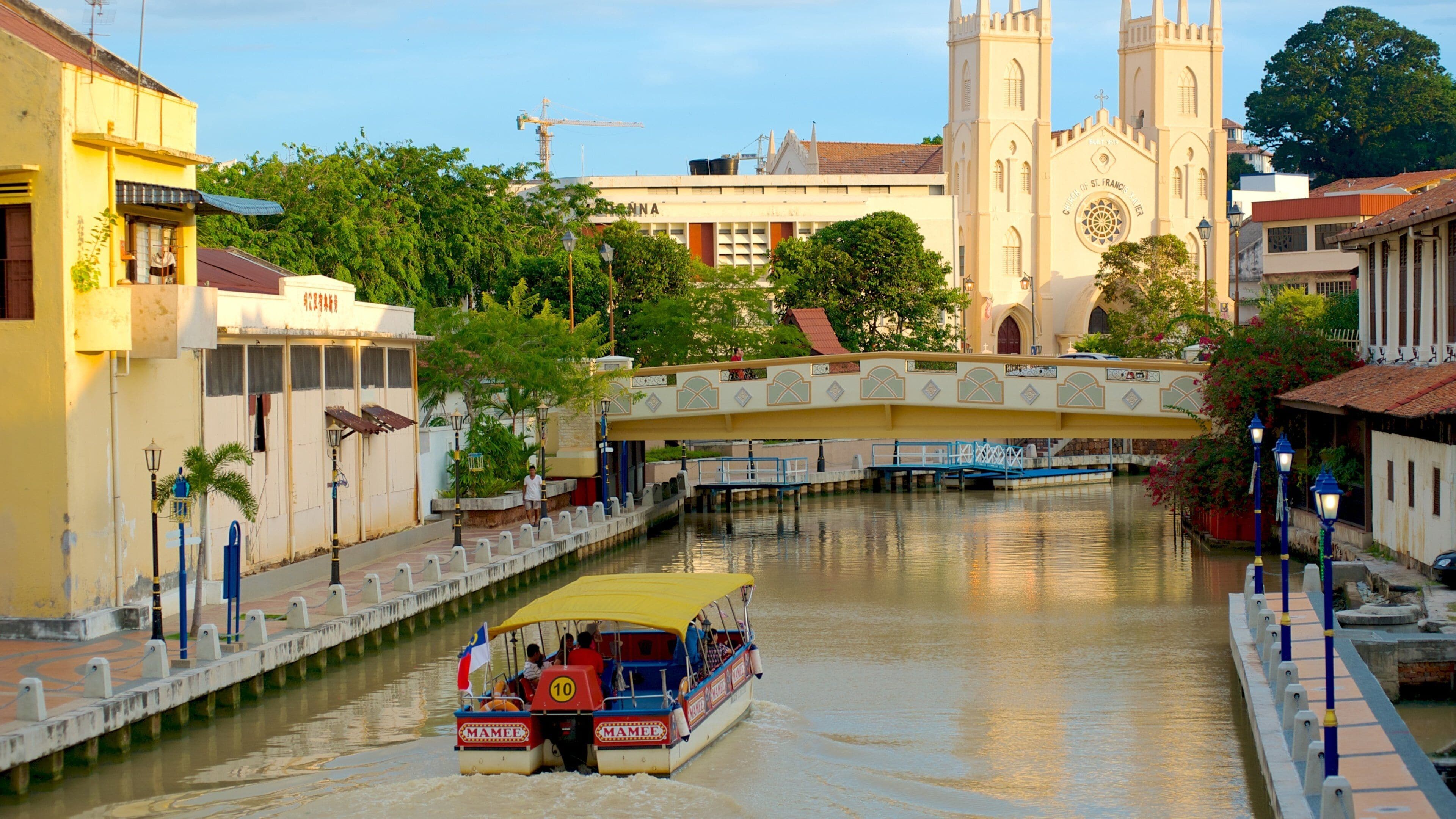 A river with a bridge, a church, and a boat.