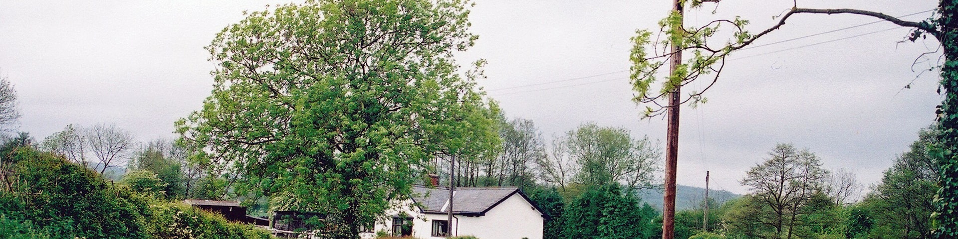 Site of former Eaton station. View northward on road to Wentnor: the impecunious Bishops Castle Light Railway, closed since 20/4/35, ran from Craven Arms (to right) to Bishop's Castle, along her beside the River Onny
