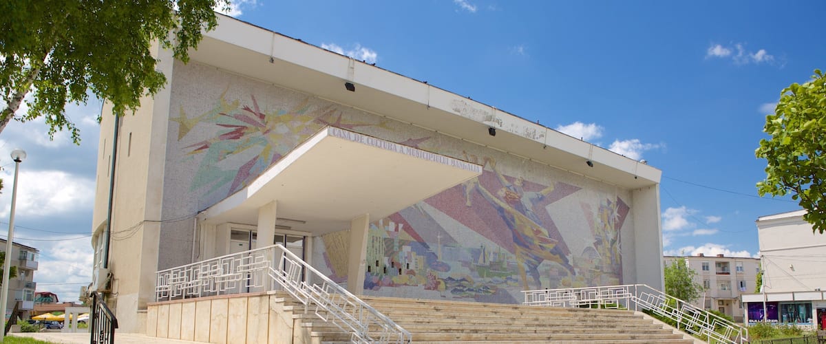 A building with a colorful mural and a staircase leading to the entrance.