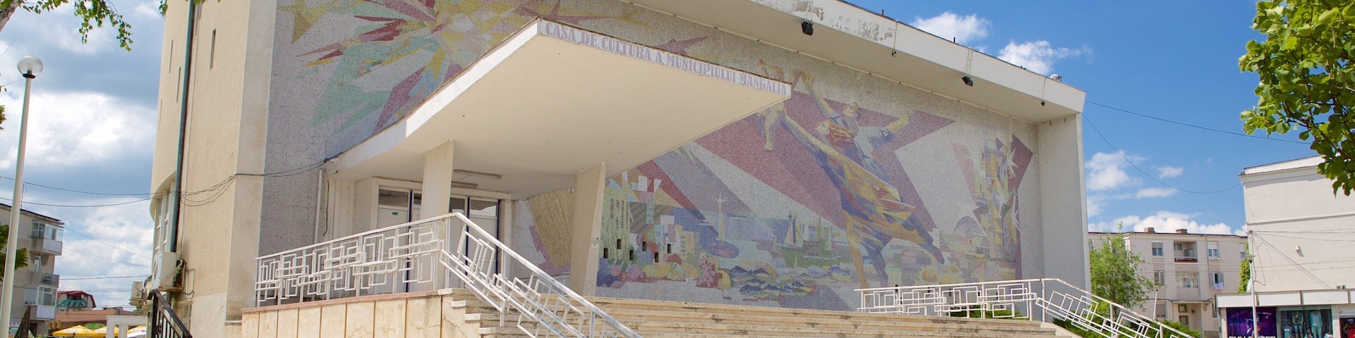 A building with a colorful mural and a staircase leading to the entrance.