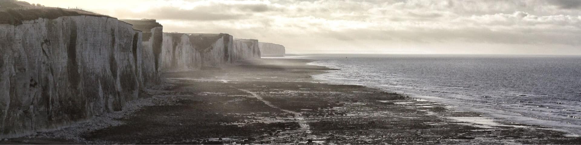 A coastal landscape with cliffs and a beach.