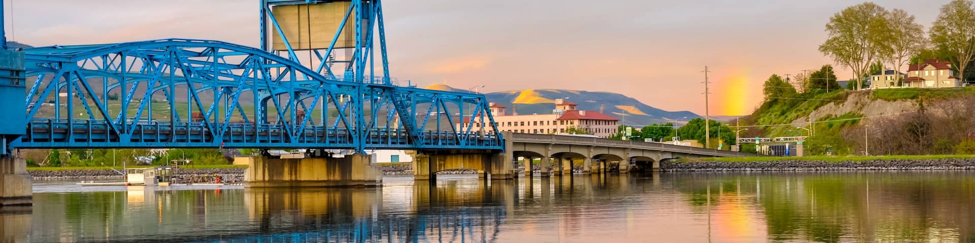 Lewiston - Clarkston blue bridge reflecting in the Snake River against evening sky