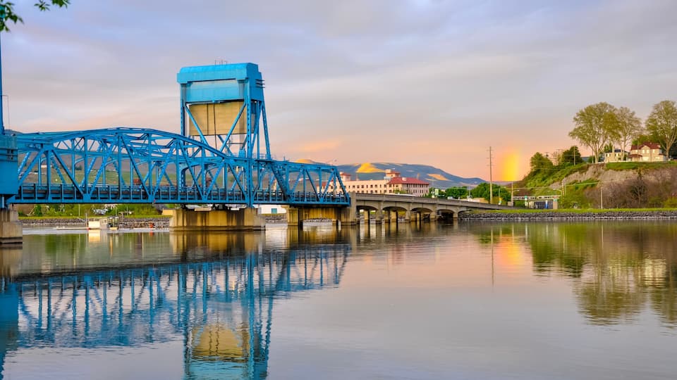 Lewiston - Clarkston blue bridge reflecting in the Snake River against evening sky