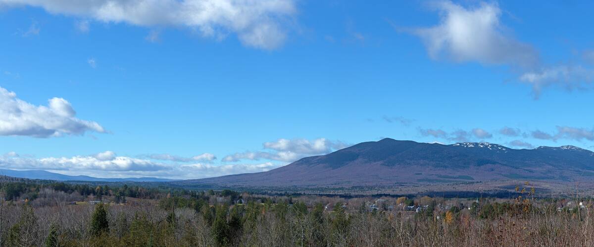 A mountain range with a clear sky and scattered clouds.
